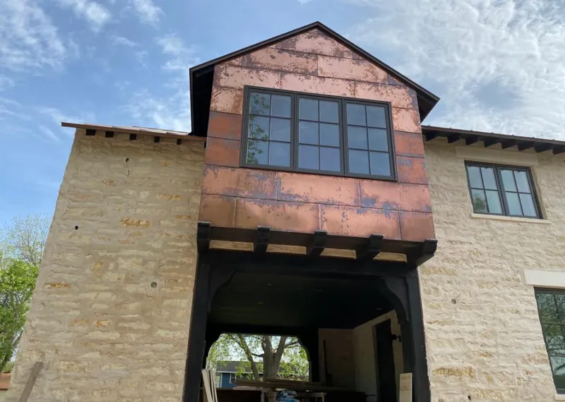 Copper metal panel facade on a stone building for Roof Repair in Grand Forks